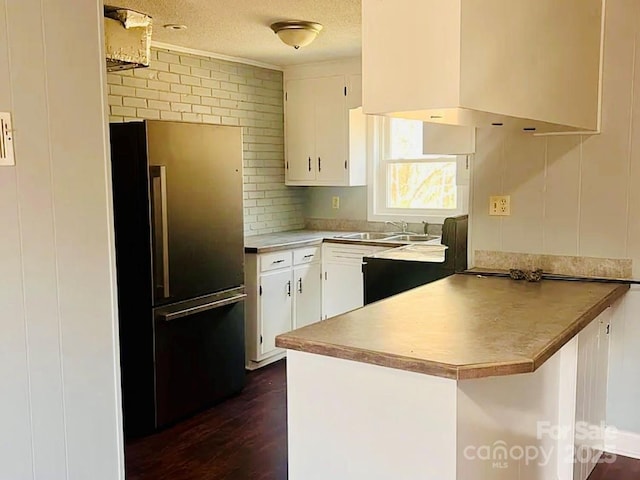 kitchen with dark wood-type flooring, sink, white cabinetry, fridge, and kitchen peninsula