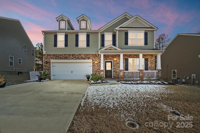 craftsman-style house featuring central AC unit, concrete driveway, an attached garage, a porch, and brick siding