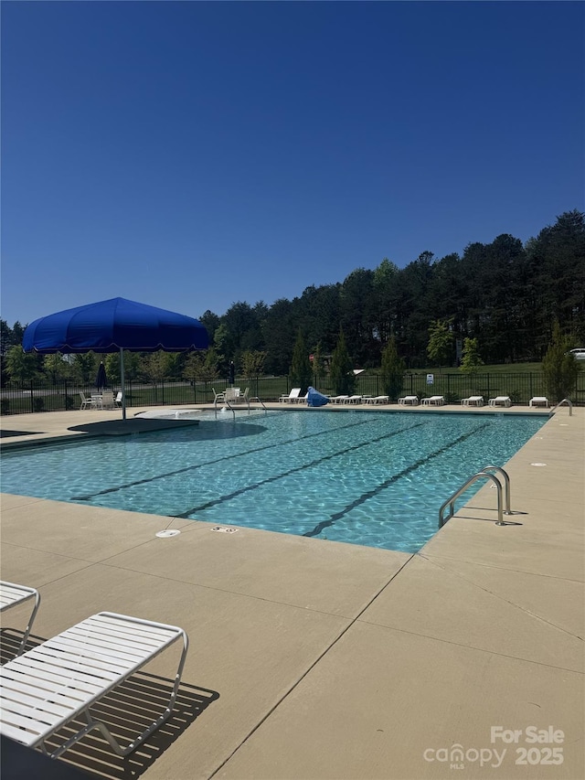 community pool with fence and a patio area