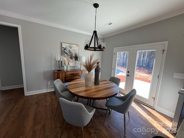 dining room with french doors, visible vents, crown molding, and wood finished floors