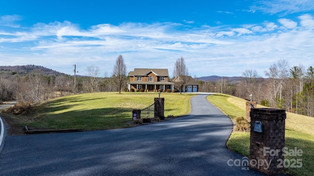 view of front of property with a mountain view and a front lawn