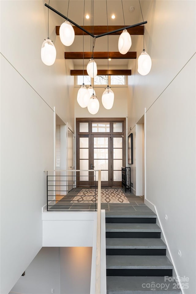 stairway featuring recessed lighting, baseboards, and a high ceiling