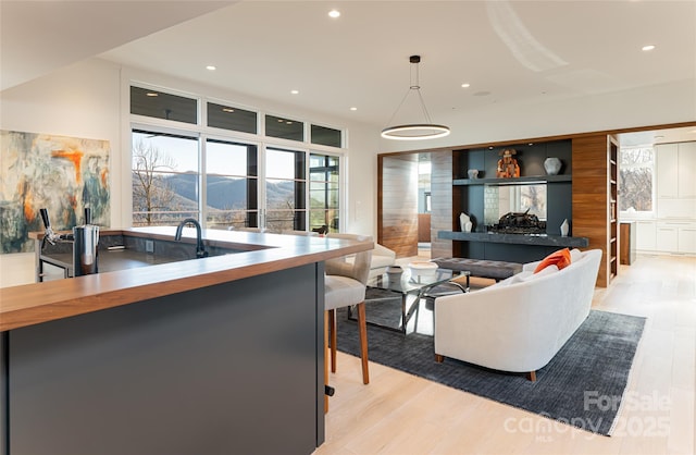 living area with light wood-style flooring, a mountain view, and recessed lighting