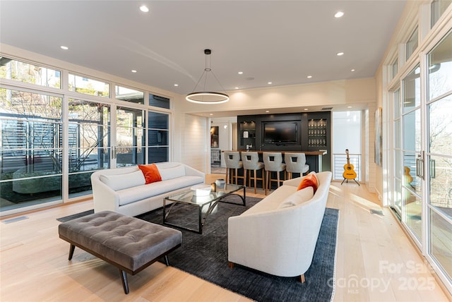 living area with light wood finished floors, recessed lighting, visible vents, and a healthy amount of sunlight