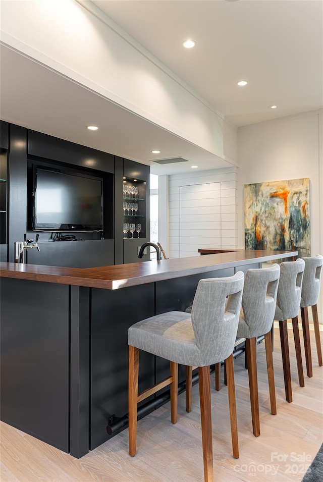 bar featuring wet bar, recessed lighting, and wood finished floors