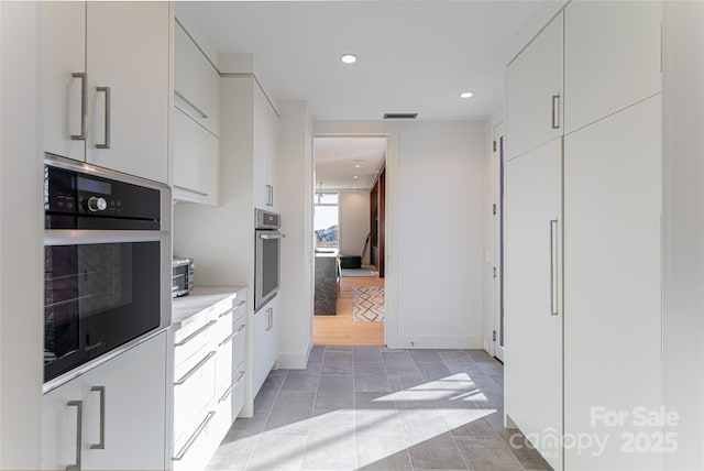 kitchen with wall oven, visible vents, light countertops, stainless steel oven, and recessed lighting