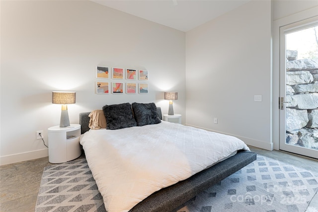 bedroom featuring access to exterior, lofted ceiling, and baseboards