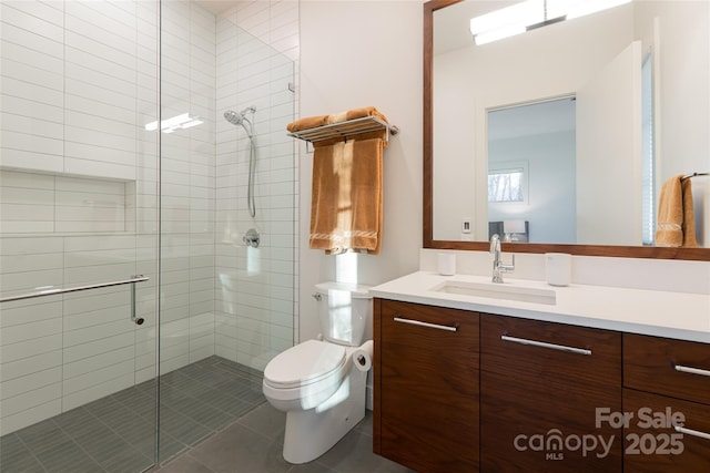 bathroom with tile patterned flooring, a shower stall, toilet, and vanity