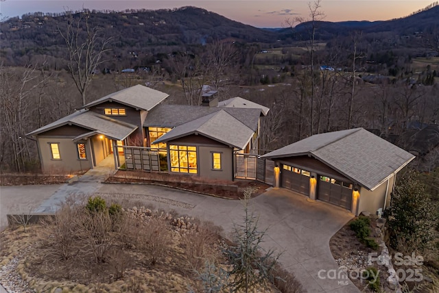 view of front of home with a garage, a mountain view, driveway, and an outdoor structure