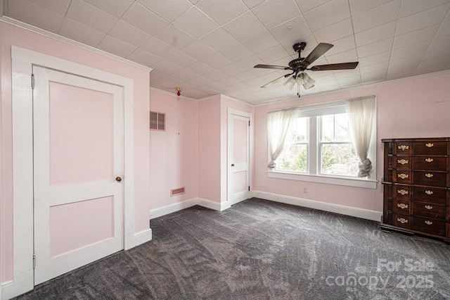 unfurnished bedroom with ornamental molding, dark colored carpet, visible vents, and baseboards