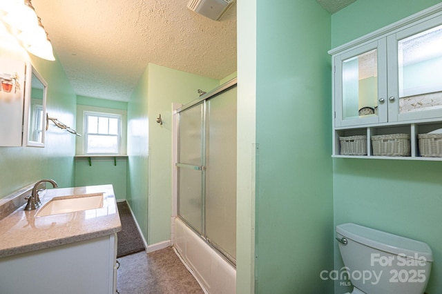 full bathroom featuring visible vents, toilet, combined bath / shower with glass door, a textured ceiling, and vanity