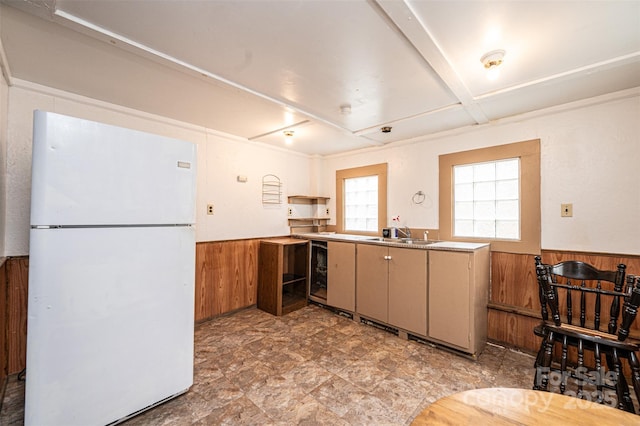 kitchen with a wainscoted wall, wooden walls, and freestanding refrigerator