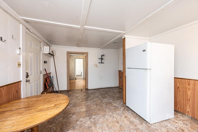 kitchen with wooden walls, wainscoting, freestanding refrigerator, and a wall mounted air conditioner