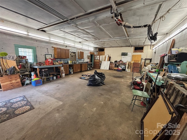 garage featuring a workshop area and concrete block wall