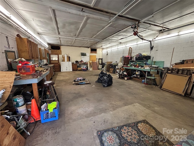 garage featuring concrete block wall and a workshop area