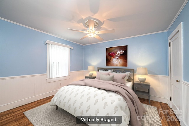 bedroom with a wainscoted wall, ceiling fan, ornamental molding, and wood finished floors