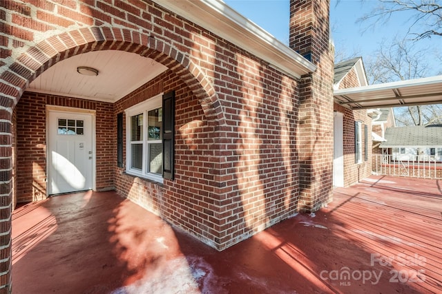 property entrance featuring brick siding and a chimney