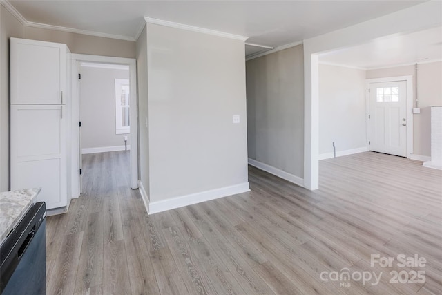 spare room featuring light wood-type flooring, crown molding, and baseboards