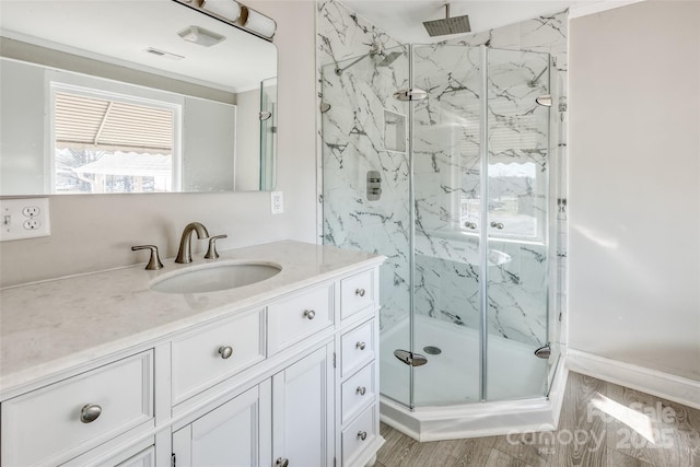 full bathroom featuring a marble finish shower, visible vents, wood finished floors, and vanity