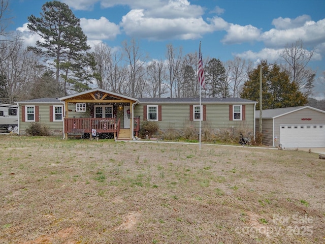 view of front of house featuring an outbuilding, a front lawn, covered porch, and a detached garage