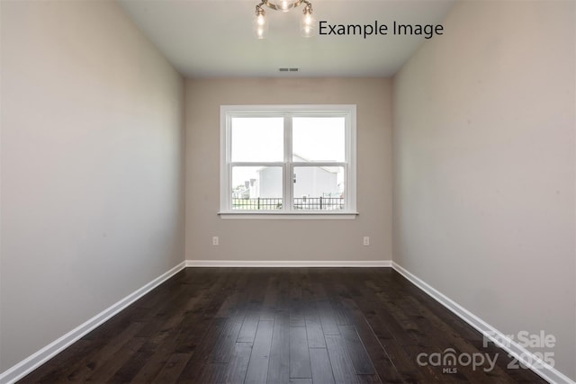 unfurnished room featuring dark wood-style floors and baseboards