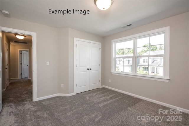 unfurnished bedroom with carpet floors, baseboards, and a closet