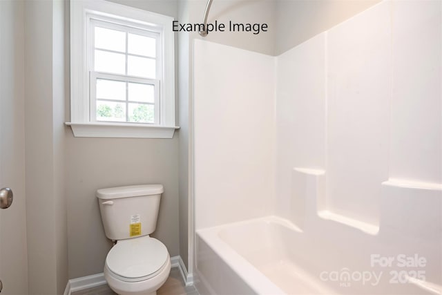 full bath with toilet and baseboards