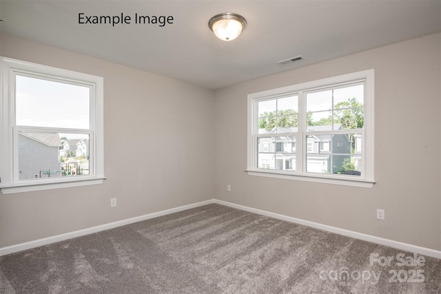 carpeted empty room featuring baseboards