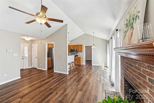 unfurnished living room with lofted ceiling, a fireplace, baseboards, and dark wood-type flooring