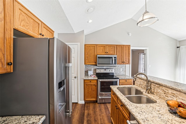 kitchen featuring light stone counters, stainless steel appliances, dark wood-type flooring, a sink, and vaulted ceiling