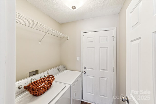 laundry room with laundry area, washer and clothes dryer, and a textured ceiling