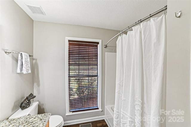 full bath featuring toilet, a textured ceiling, visible vents, and shower / bathtub combination with curtain