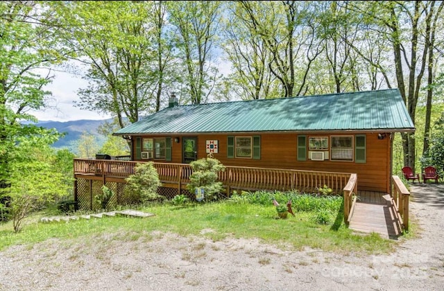 view of front of property featuring a deck with mountain view and metal roof