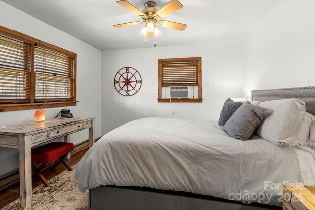 bedroom featuring ceiling fan, cooling unit, and wood finished floors