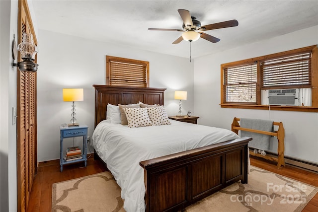 bedroom featuring ceiling fan, cooling unit, and wood finished floors