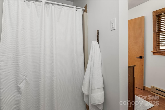 bathroom with a baseboard radiator, baseboards, and wood finished floors