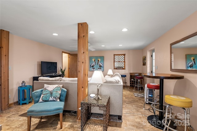 living area with recessed lighting, stone finish flooring, and baseboards