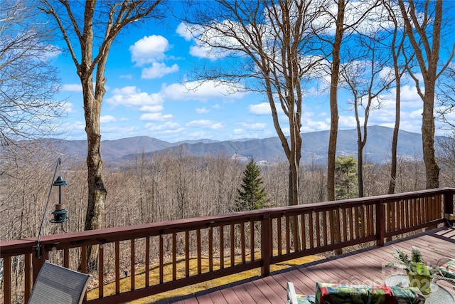 wooden deck featuring a mountain view and a forest view