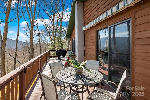 balcony with a deck with mountain view and outdoor dining space