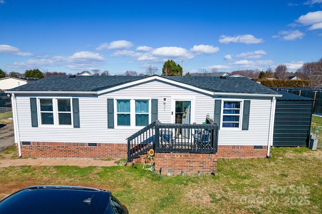 manufactured / mobile home with a shingled roof, a front yard, crawl space, a wooden deck, and stairs