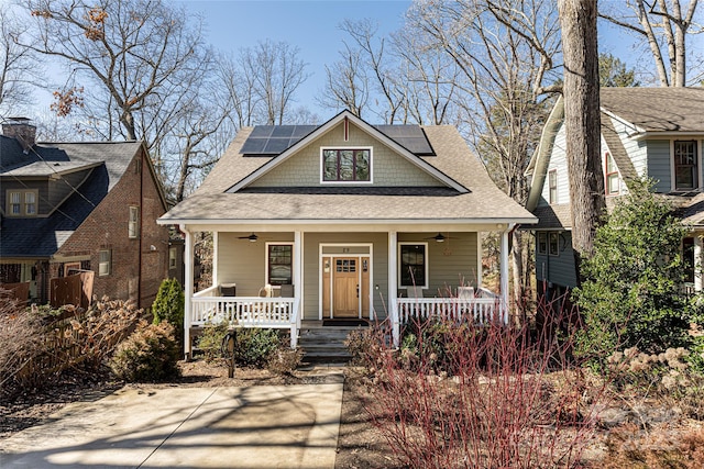 view of front of house with a ceiling fan, covered porch, and roof mounted solar panels