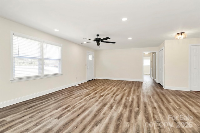 unfurnished living room featuring a ceiling fan, recessed lighting, light wood finished floors, and baseboards