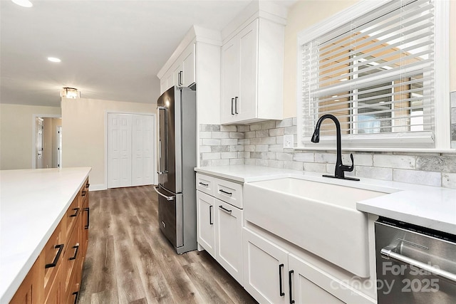 kitchen with appliances with stainless steel finishes, light countertops, and white cabinets