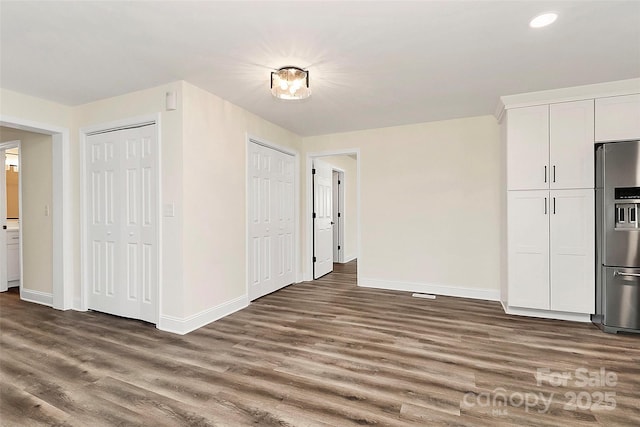 interior space featuring baseboards, dark wood finished floors, and recessed lighting