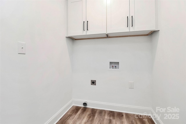 clothes washing area with dark wood finished floors, hookup for a washing machine, cabinet space, electric dryer hookup, and baseboards