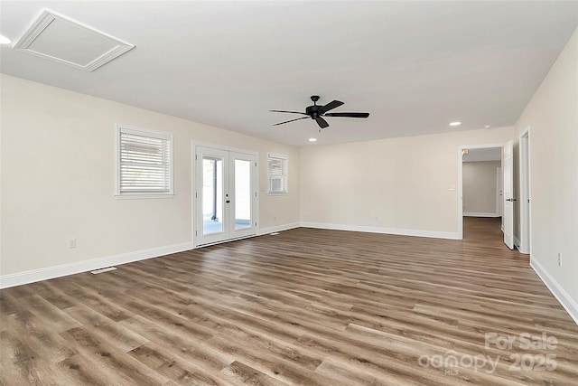 spare room with attic access, baseboards, wood finished floors, french doors, and recessed lighting