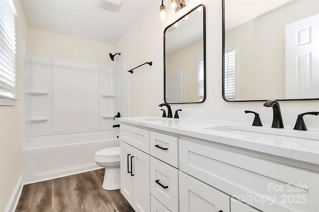 full bathroom featuring toilet, shower / bathtub combination, a sink, and wood finished floors