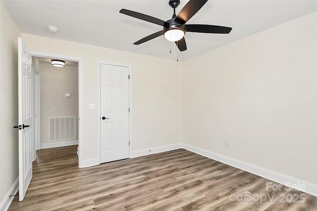 unfurnished bedroom with a ceiling fan, wood finished floors, visible vents, and baseboards