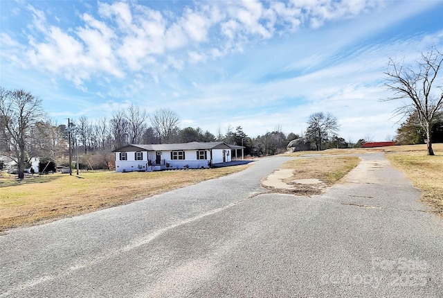 view of front facade featuring driveway and a front yard