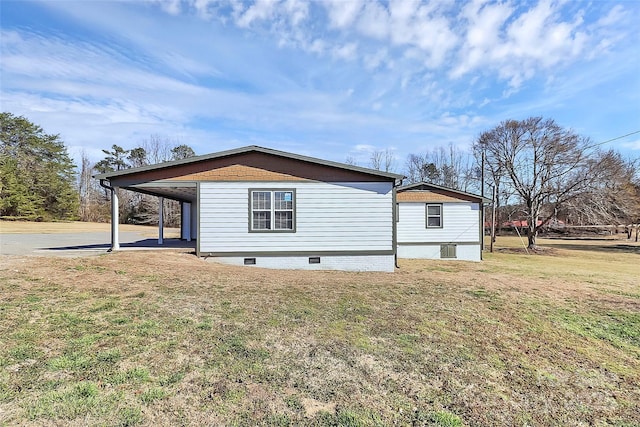 view of property exterior featuring crawl space, an attached carport, and a lawn